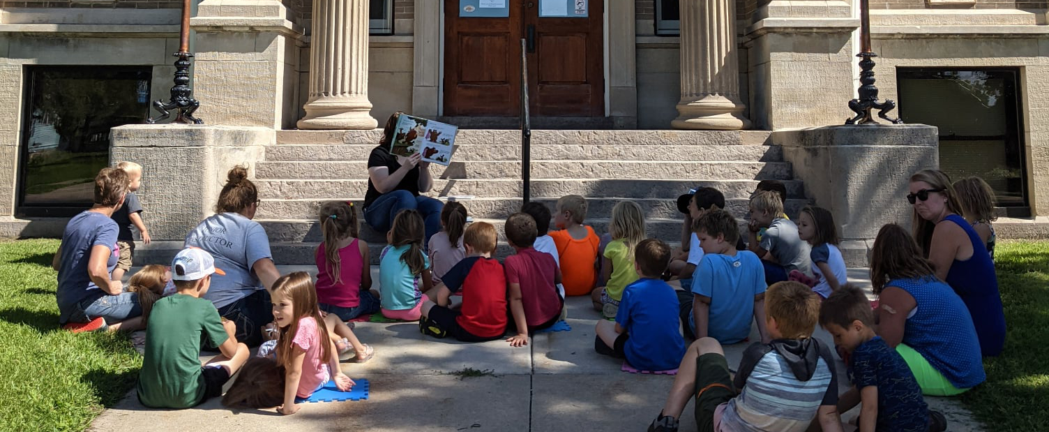 children's story reading outside on the library steps